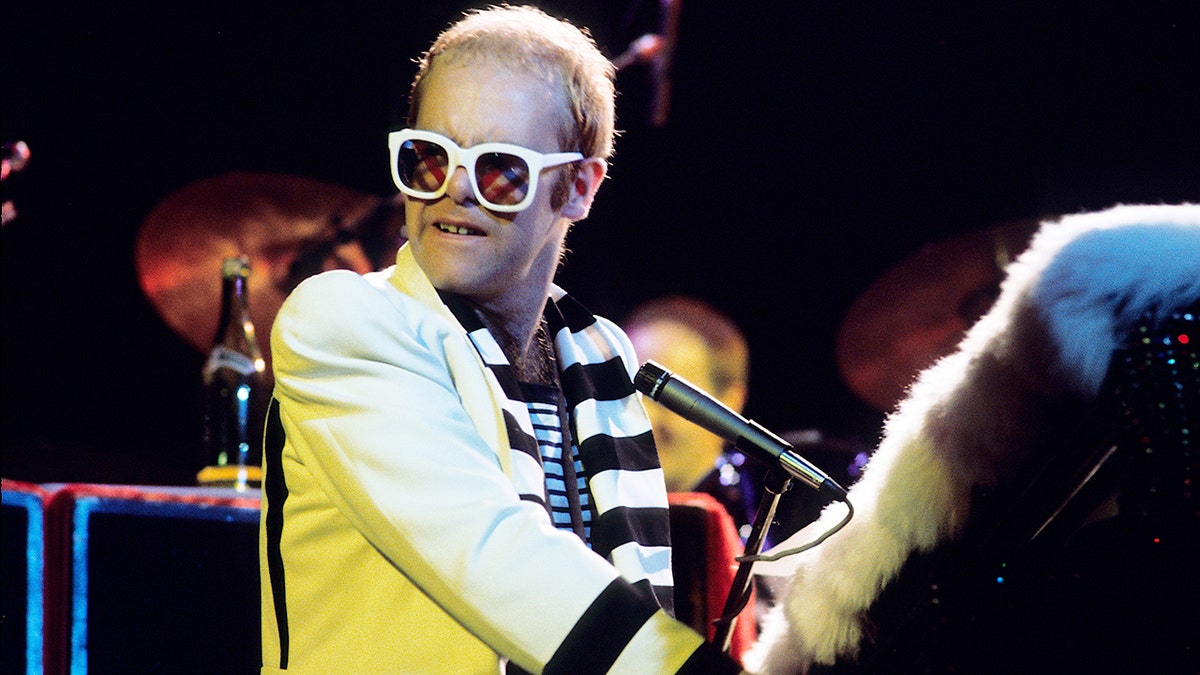 Elton John performing on stage in 1975
