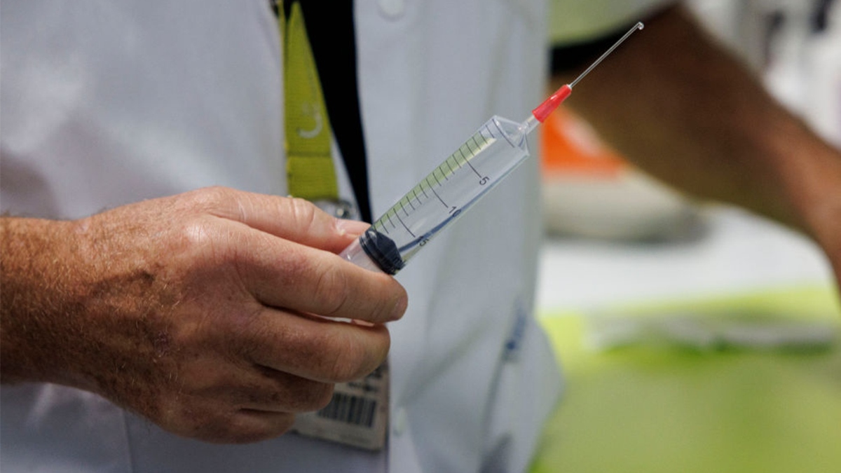 A doctor prepares a syringe