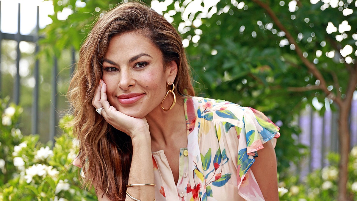 Eva Mendes smiling in front of trees