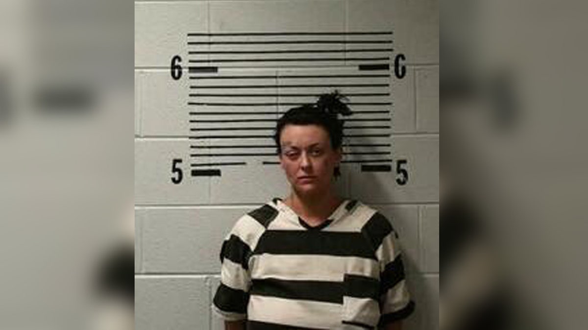 Grace Kelley wears black and white jail uniform in Alabama mugshot