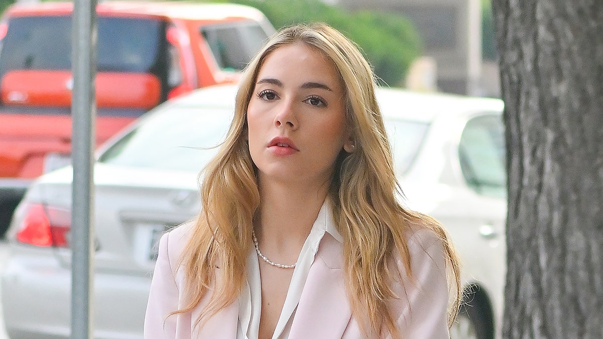 Haley Pullos wears pink suit outside of court.