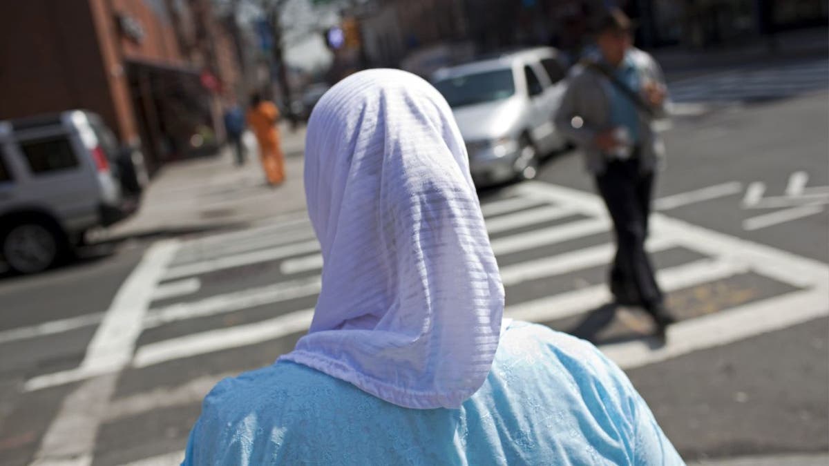 A woman crossing the street in New York City wearing a hijab