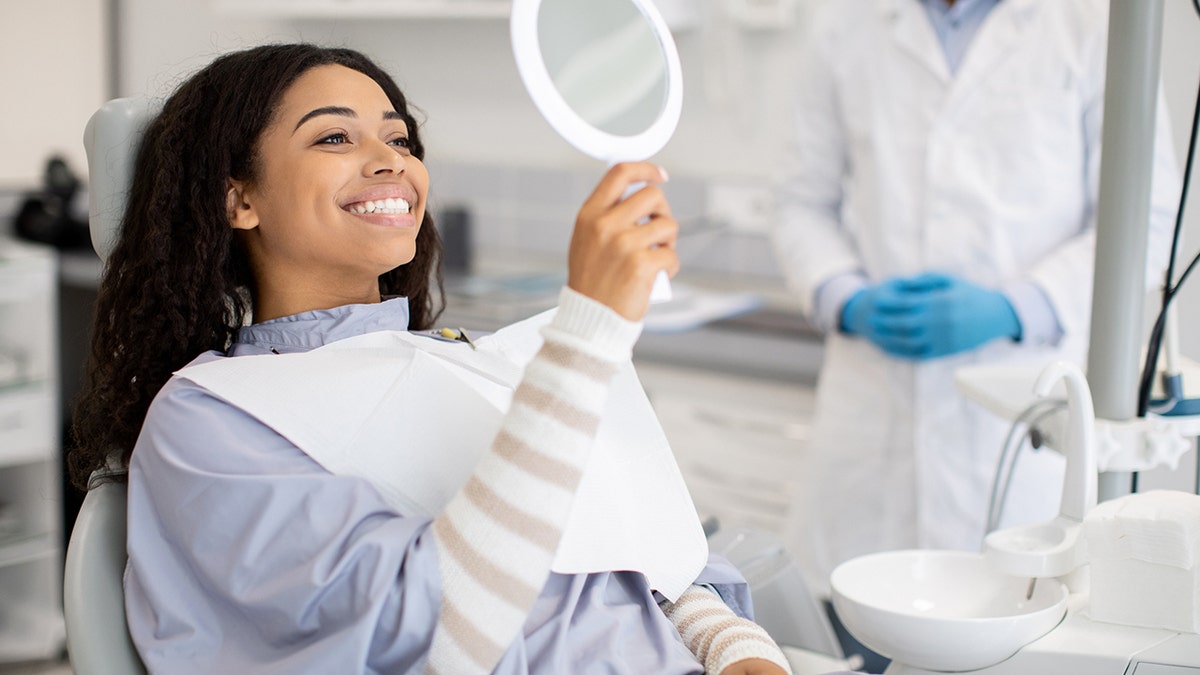 woman checks her teeth at the dentist