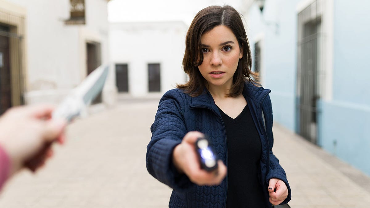 mujer usando una pistola eléctrica