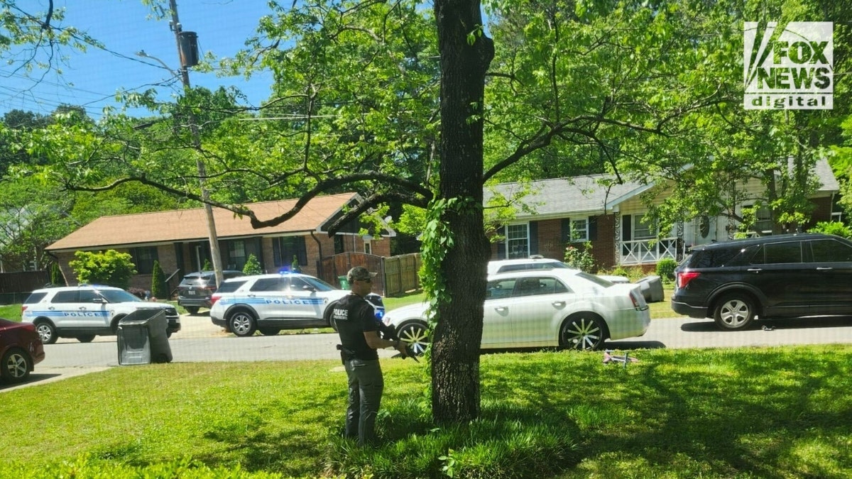 An officer holds a firearm on Galway Drive in Charlotte