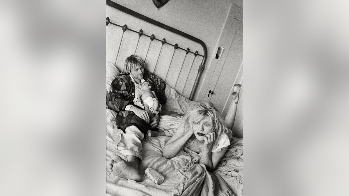 Black and white photo of Kurt Cobain and Courtney Love in bed with Francis