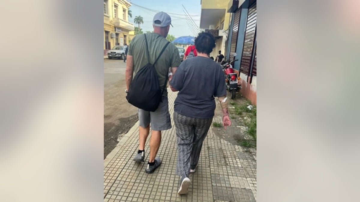 Julie Lenkoff being helped by Jay Campbell walk around the African island of São Tomé.