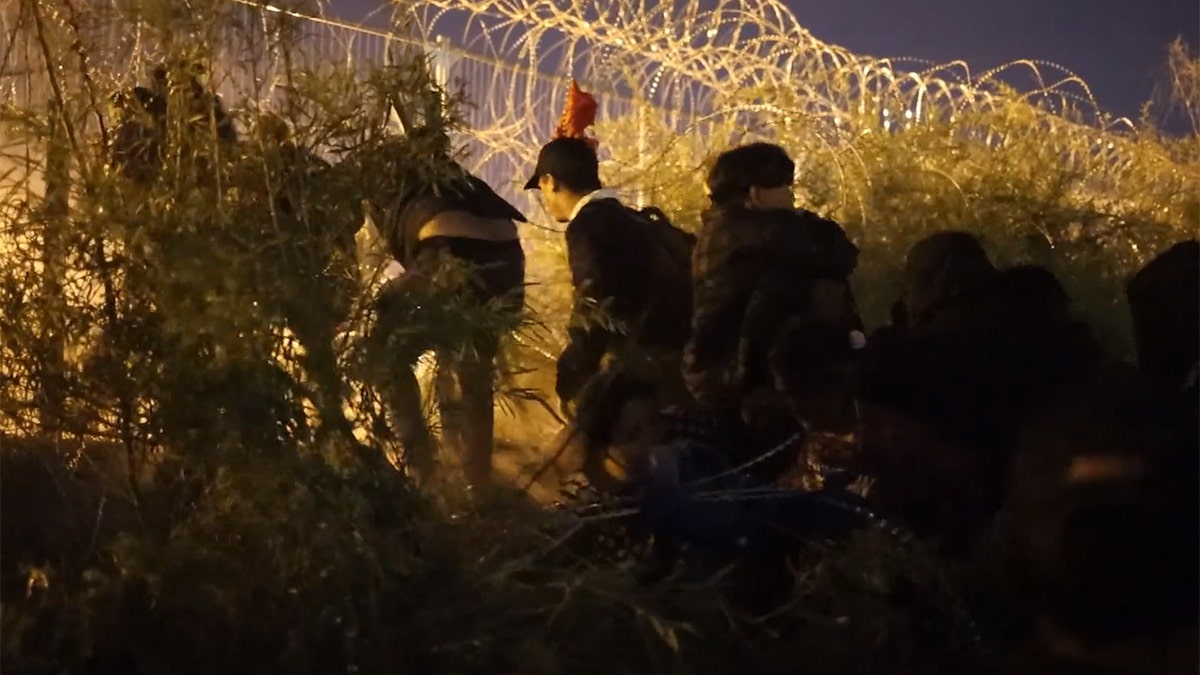 nighttime border surge thru concertina wire fence
