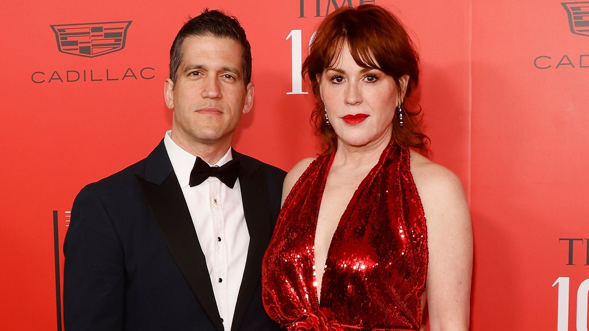 Panio Gianopoulos in a tuxedo and Molly Ringwald in a sparkly plunging red dress
