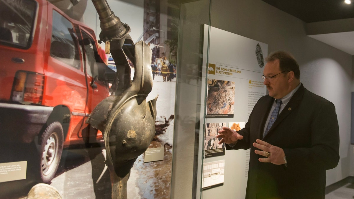 Barry Black stands next to the rear axle of the Ryder rental truck now displayed in a museum