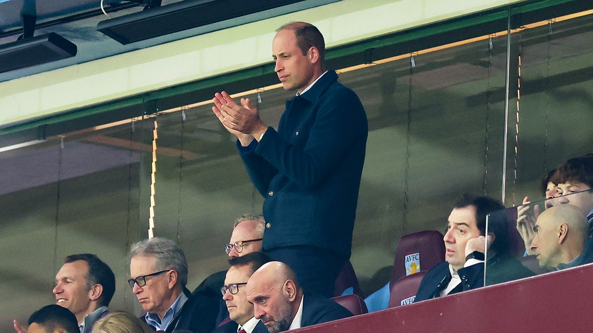 Prince William stands up during soccer game.