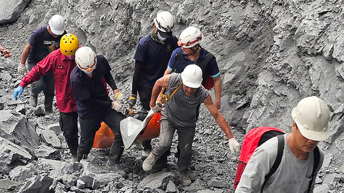 Firefighters evacuate a body from a quarry in Taiwan