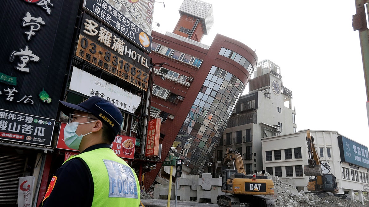 A police officer stands near partially collapsed building in Taiwan