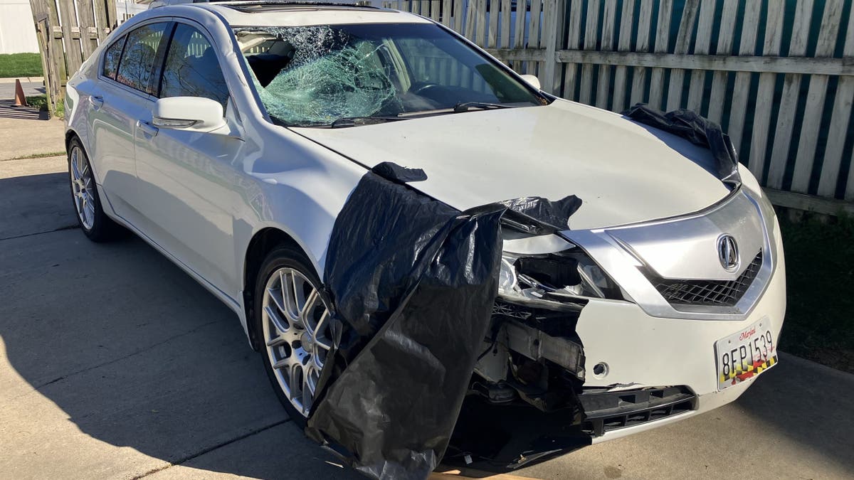 White Acura with damage to hood and windshield. 