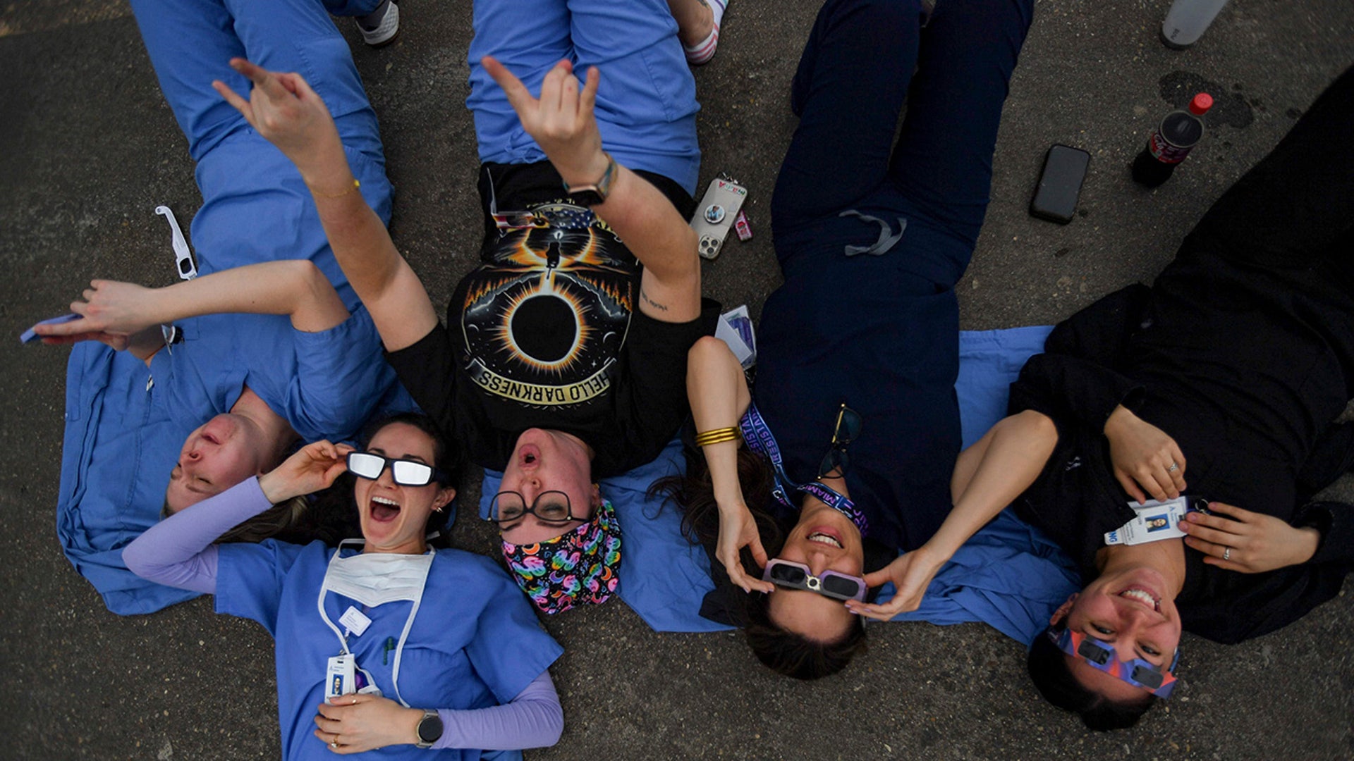 Hospital personnel at Dell Seton Medical Center cheer from the top floor of the hospitals parking garage during the early stages leading up to the totality of the solar eclipse