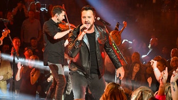 Luke Bryan slips on fan's cellphone, jokes his 'lawyer will be calling'