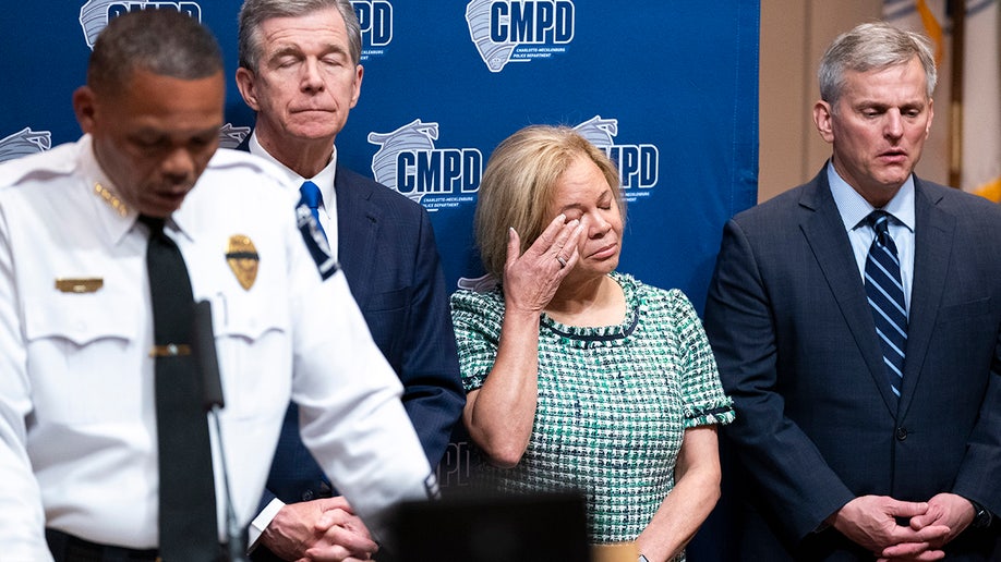 Charlotte Mayor Vi Lyle wipes her eye as Charlotte Police Chief Johnny Jennings speaks to reporters