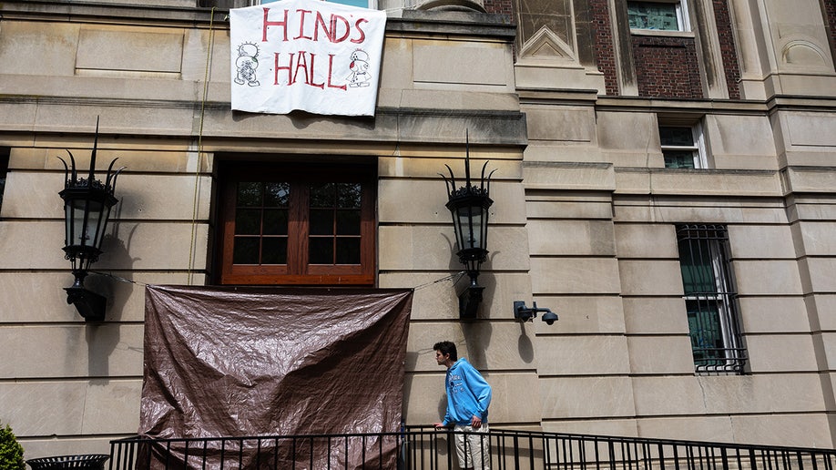 Un estudiante de Columbia observa los daños en las ventanas de una puerta del Hamilton Hall de la Universidad de Columbia