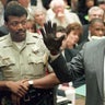 O.J. Simpson shows the jury a new pair of Aris extra-large gloves, similar to the gloves found at the Bundy and Rockingham crime scene