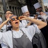 Restaurant workers in the Flatiron district of Manhattan take a break to view the solar eclipse