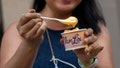A woman's Van Leeuwen new Kraft mac and cheese flavor ice cream melts at a popup truck near Union Square on July 14, 2021, in New York City. The new flavor was released in honor of National Macaroni and Cheese Day.