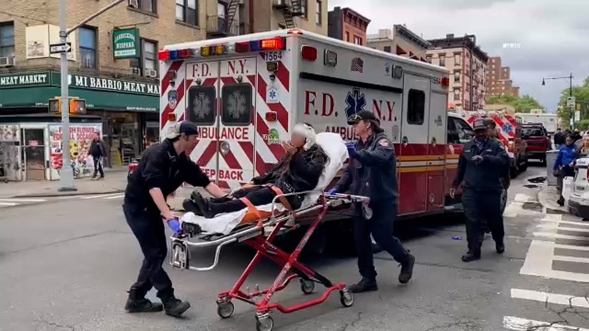 A New York City assault victim is taken to an ambulance.