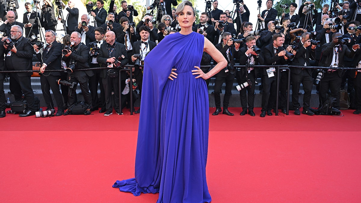 Andie Macdowell walked the red carpet at the Cannes Film Festival in a blue gown with a dramatic cape flowing down her right arm.