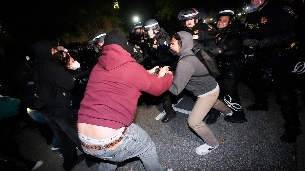 Two protesters clashing with police