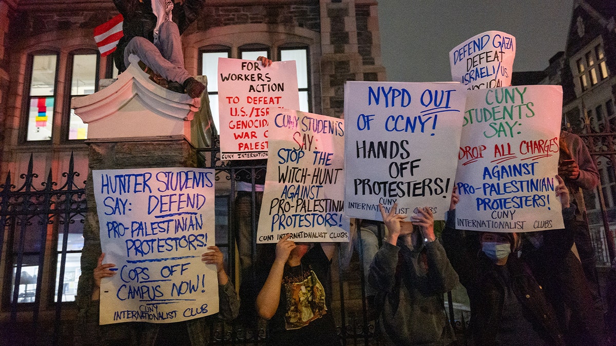 Pro-Palestinian protesters hold signs in CCNY