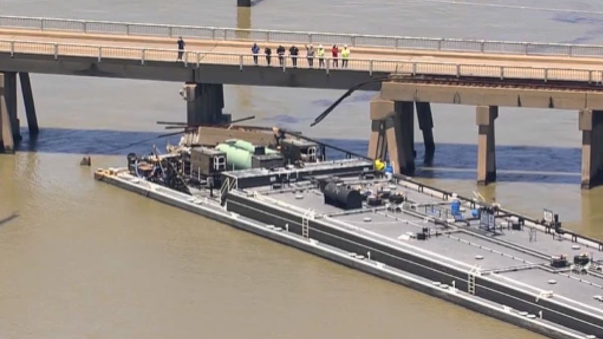 A large barge against a bridge