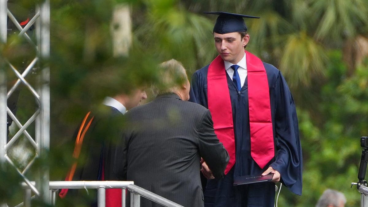 Barron Trump con toga y birrete recibe su diploma