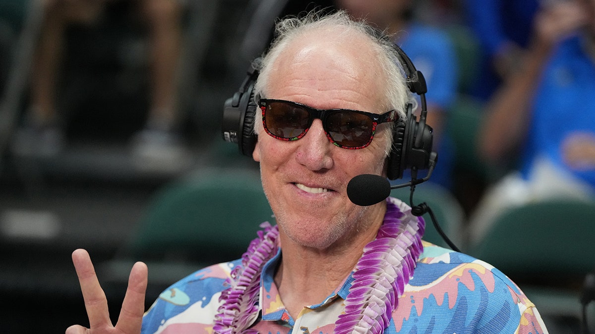 Bill Walton flashes a peace sign for a photo