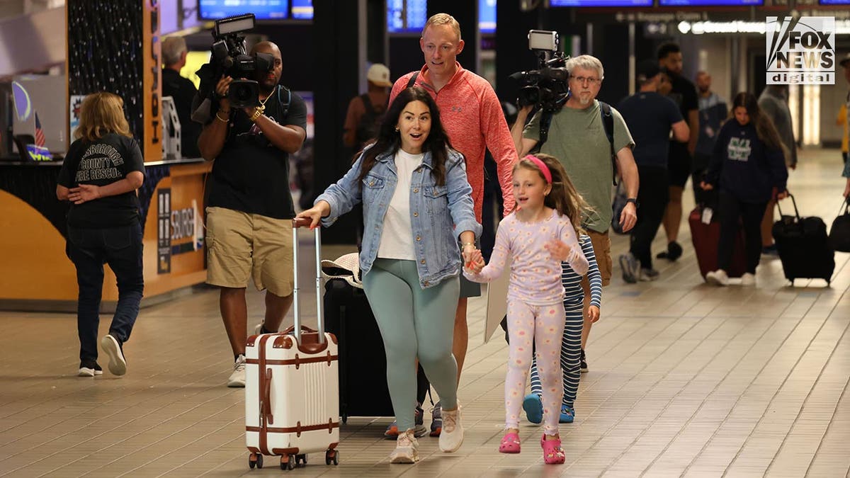 Bryan Hagerich walks with his family in the airport concourse