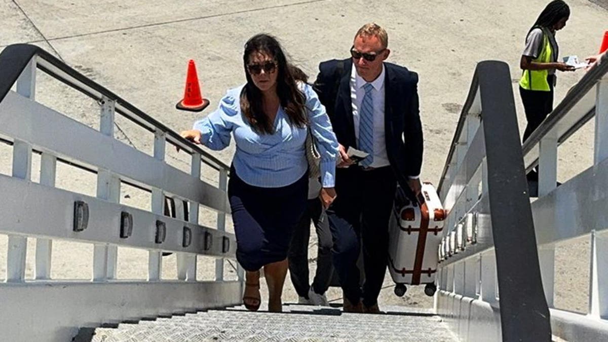 Bryan Hagerich and his wife, Ashley climb the stairs to board a plane