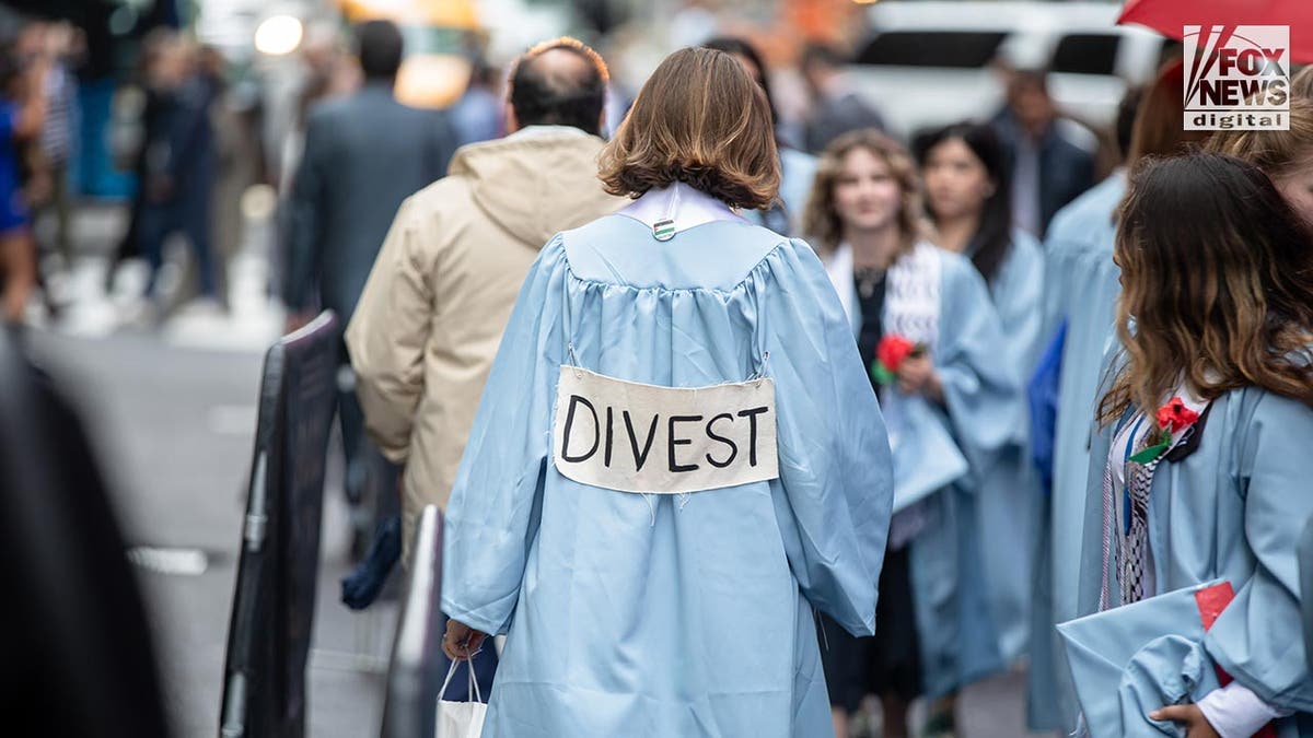Columbia graduate in cap and gown outside Radio City Music Hall