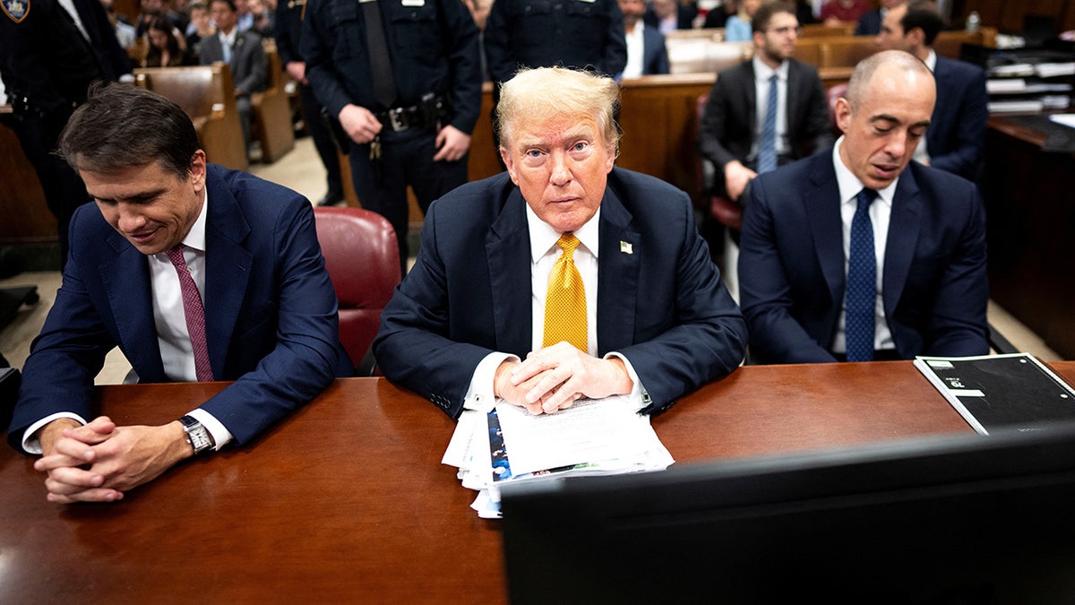 Donald Trump at defense table with attorneys in courtroom