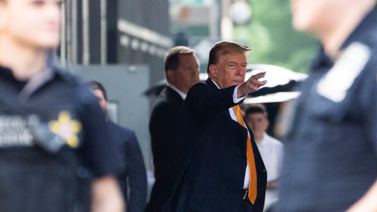Donald Trump waves while leaving Trump Tower on his way to Manhattan criminal court
