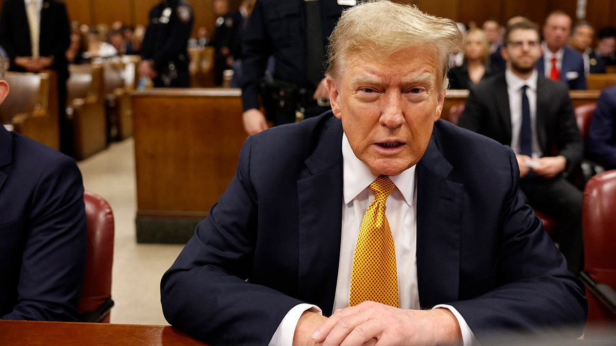 Donald Trump sitting at defense table in courtroom
