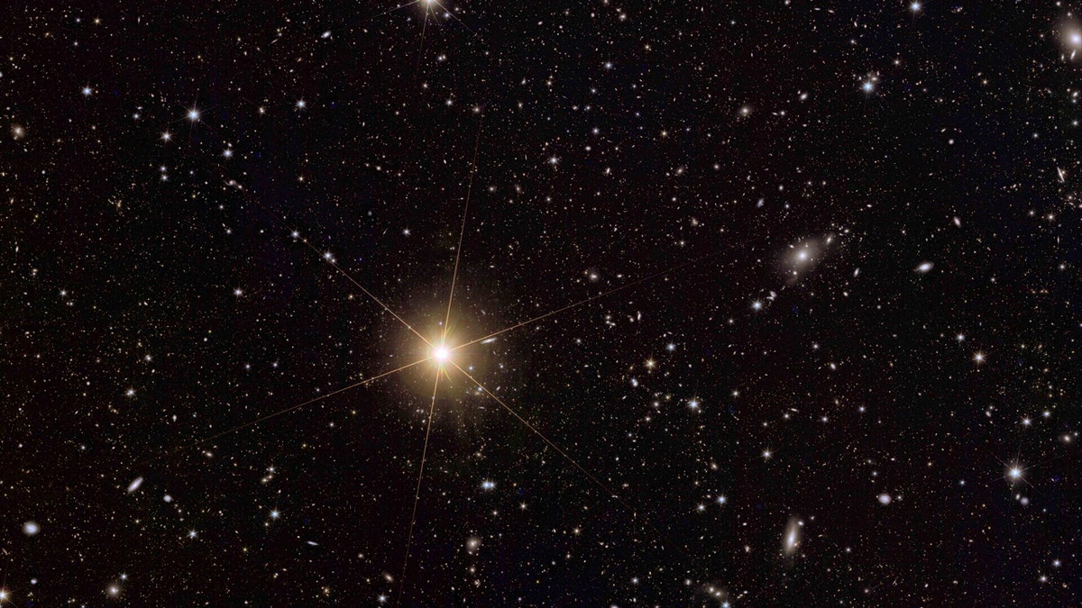 One particularly shining star is seen among many other, smaller lights in the vast black expanse of space.