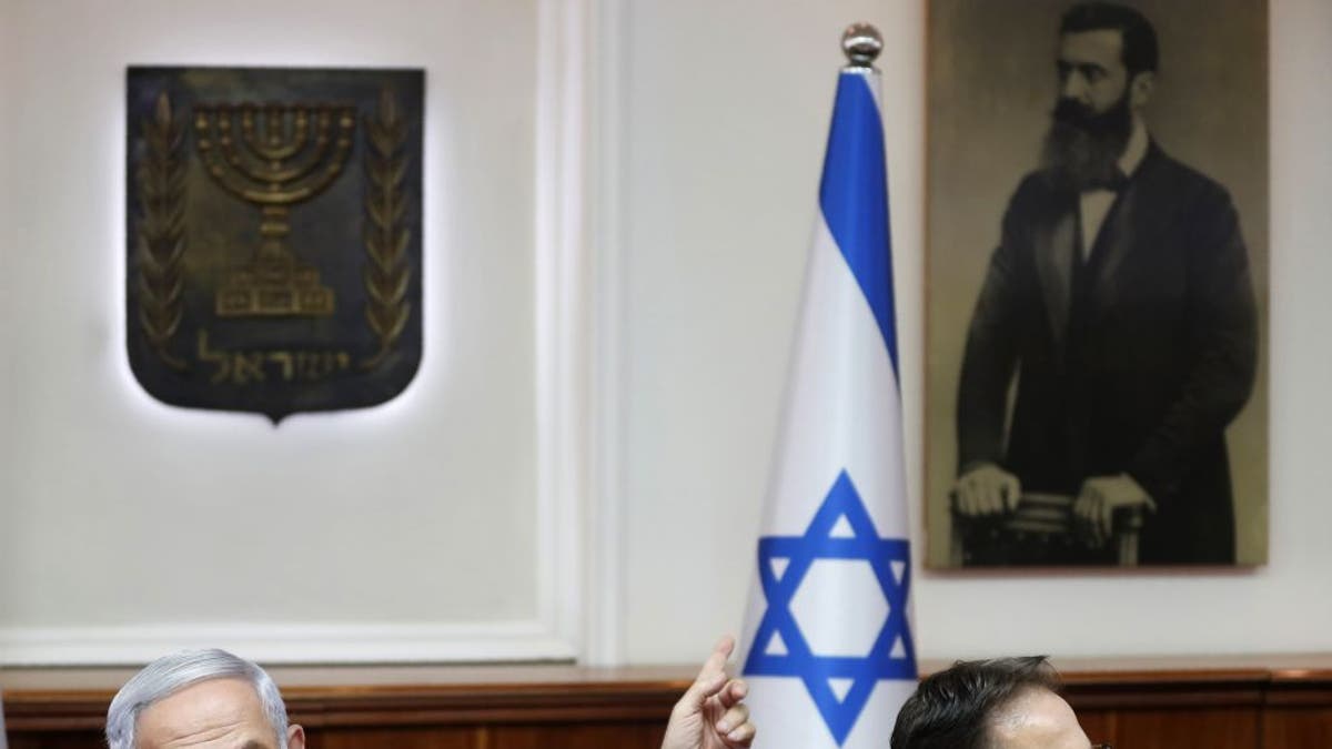 Benjamin Netanyahu, left points to Israel flag
