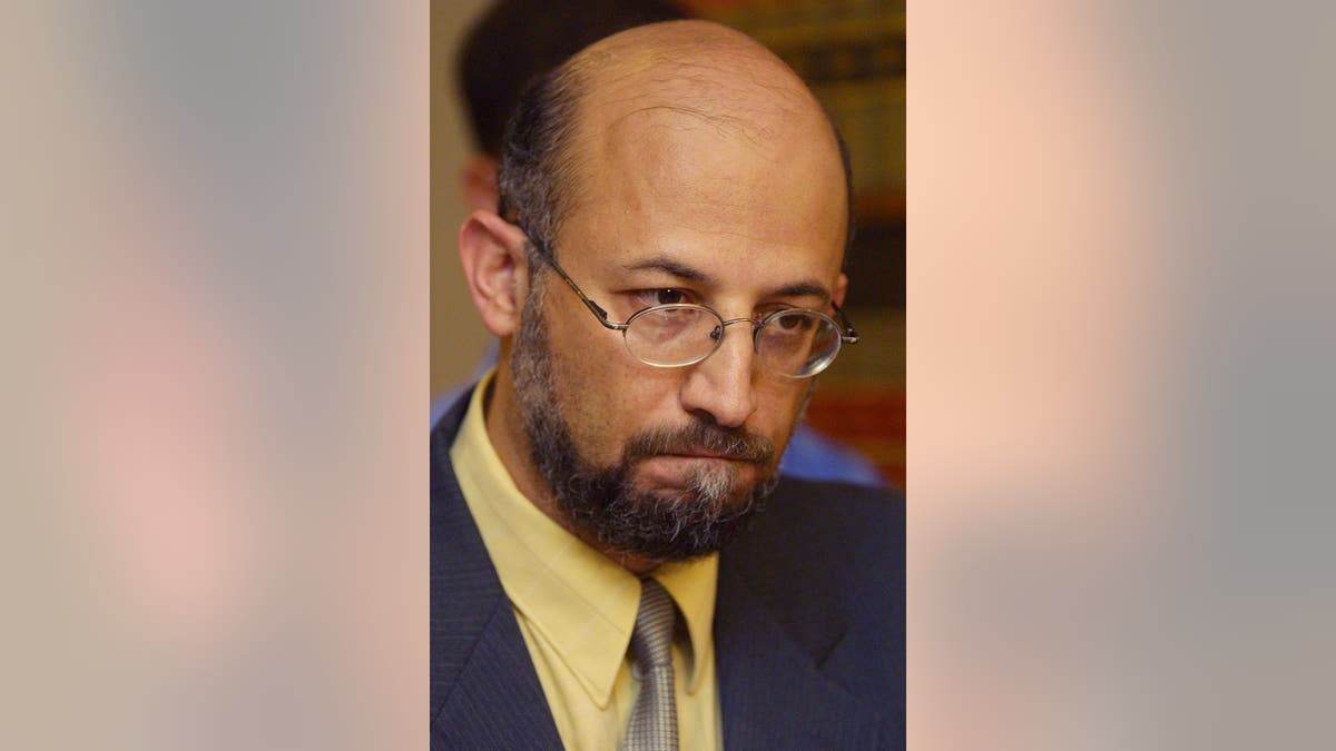 Professor Sami Al-Arian wearing a yellow shirt and dark jacket as he denies Ties To Terrorists at news conference in 2001