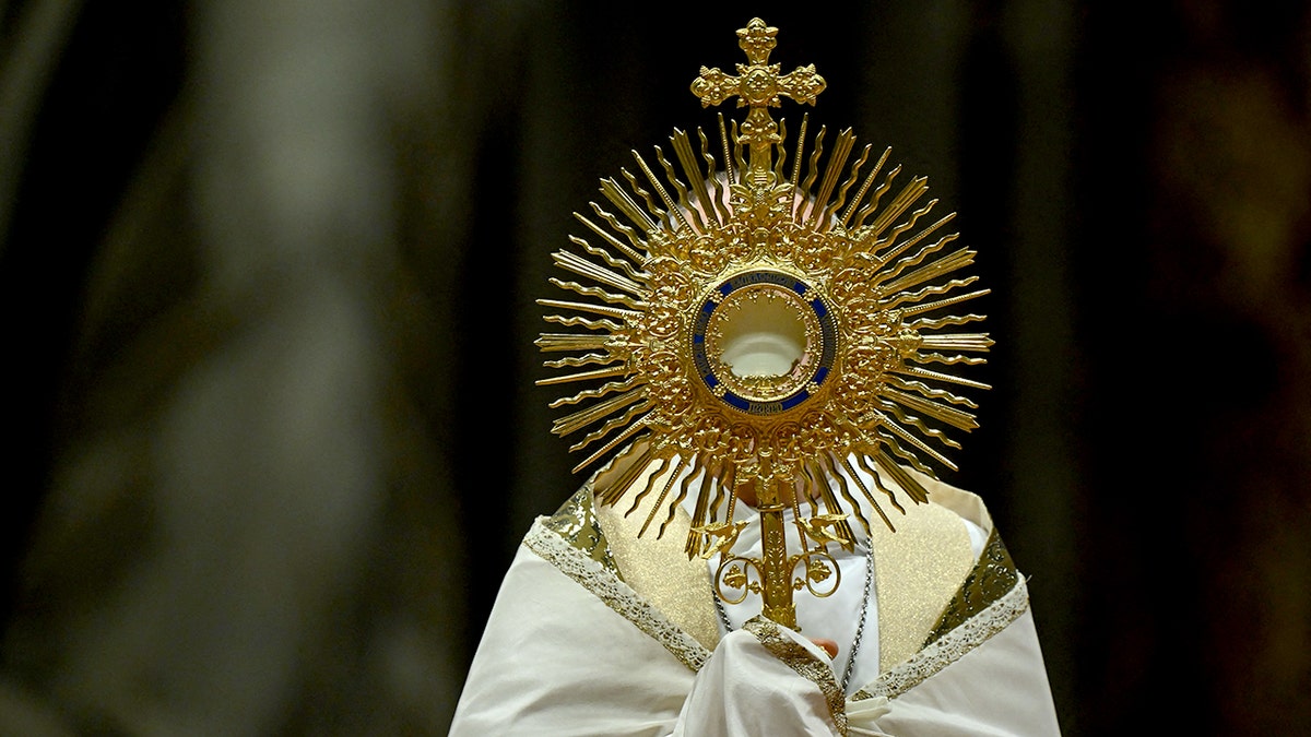 A priest holds the Monstrance during the Eucharistic adoration 