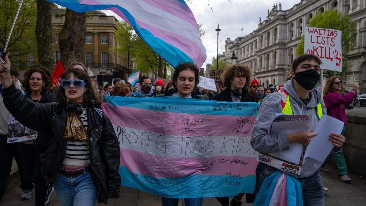 Trans-rights activists take part in a protest against the ban on hormone blockers in London, England.