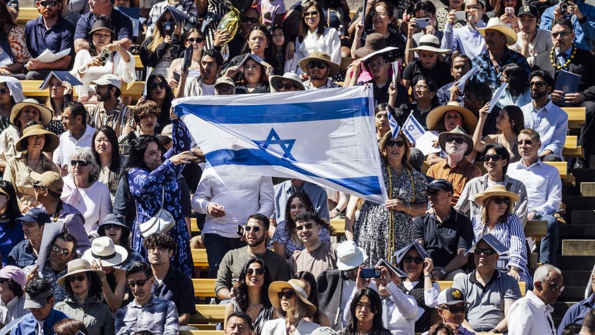 Grads holding giant Israeli flag