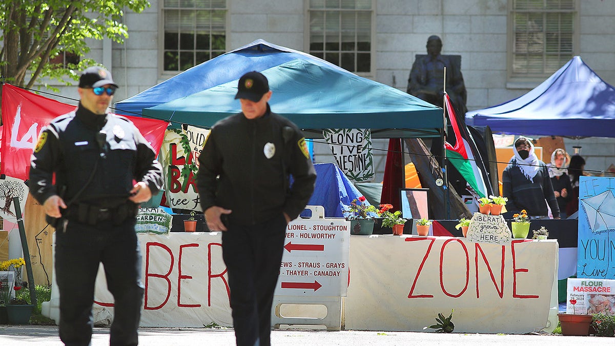 Police walk past Harvard anti-Israel encampment