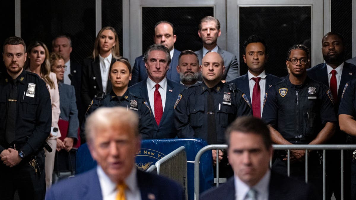 Supporters of Donald Trump, including, from center left, North Dakota Gov. Doug Burgum, Rep. Cory Mills and Vivek Ramaswamy listen as the former president speaks to the media at the end of the day's proceedings in his trial in Manhattan Criminal Court.