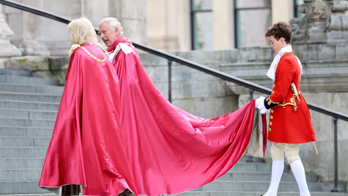 page holding charles and camillas robes on steps on st. pauls