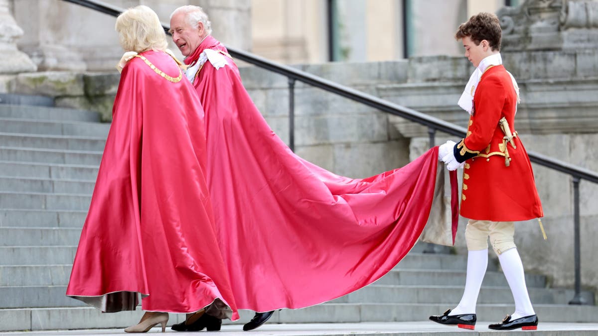 page holding charles and camillas robes on steps on st. pauls