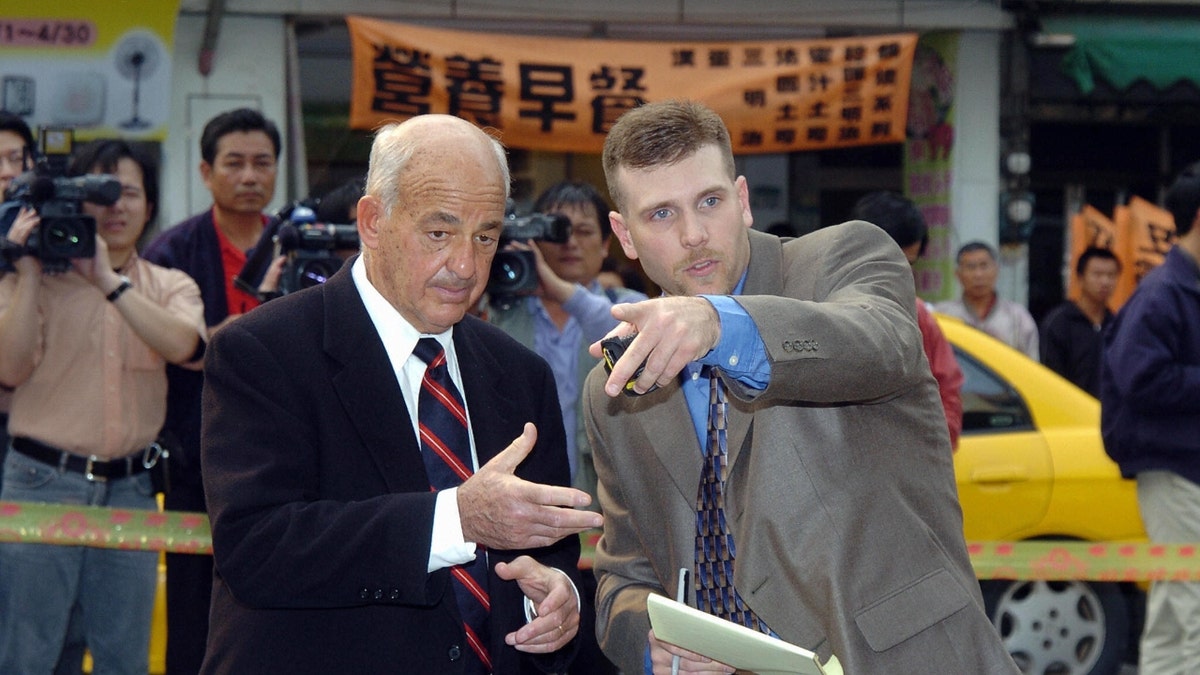 Michael Haag (R), a US crime scene investigator, talks with Dr. Cyril H. Wecht while gathering evidence from the site in Tainan, 29 March 2004, where an assassination attempt was made on President Chen Shui-bian 19 March.