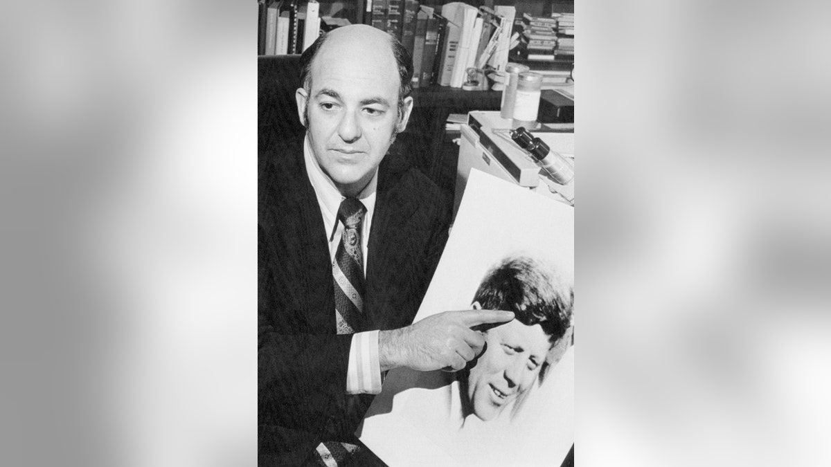 Dr. Cyril Wecht points to a photo of John F. Kennedy